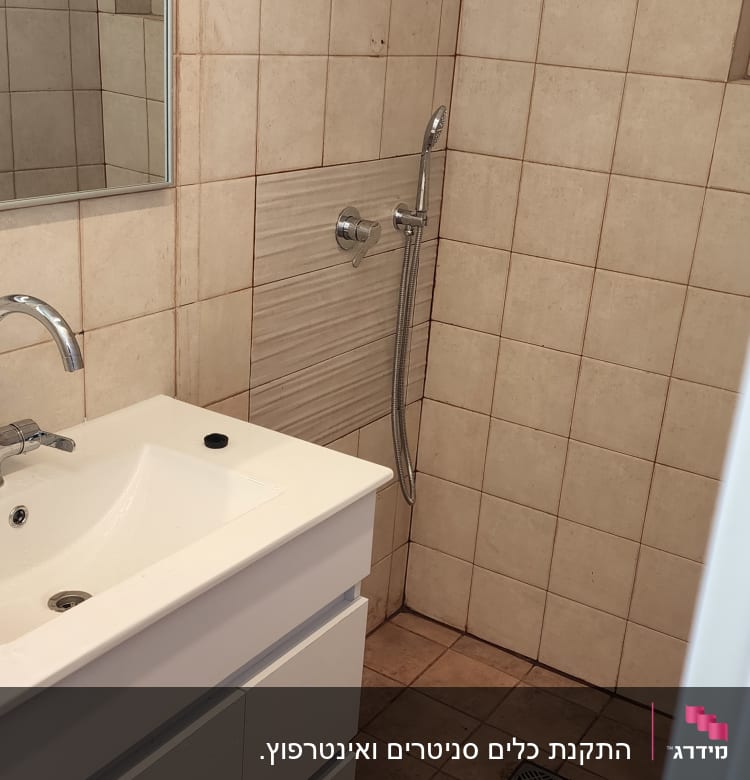 כיור עם ברז ומקלחת עם ראש מקלחת